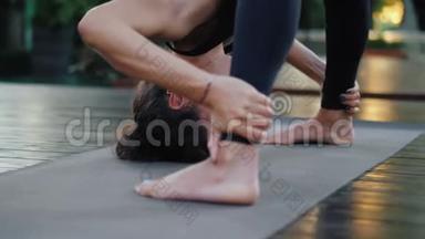 专业体操运动员健身教练在瑜伽垫上赤脚站立。柔韧的女人伸展